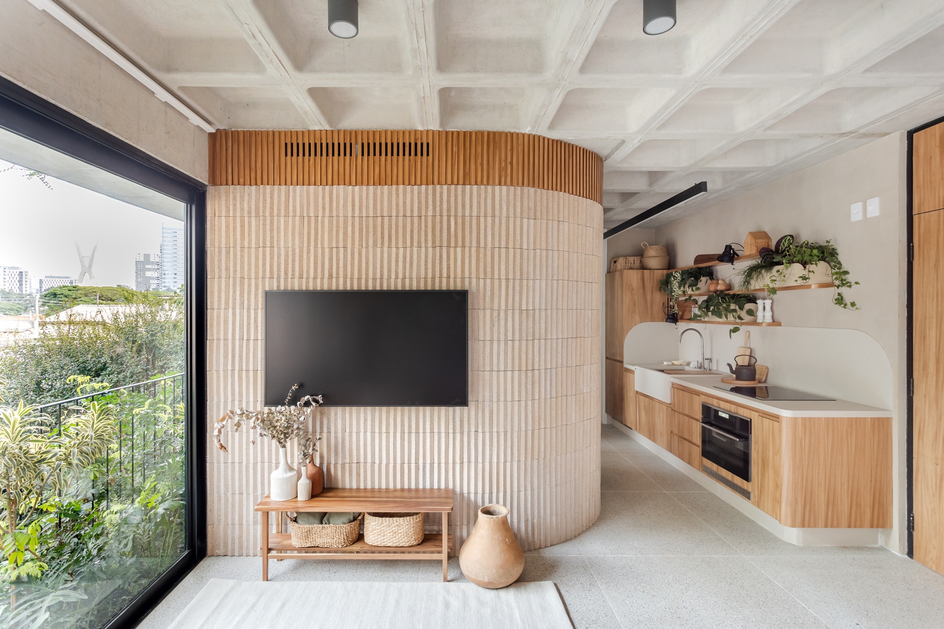 Sala e cozinha integradas em tons neutros e detalhes terrosos
