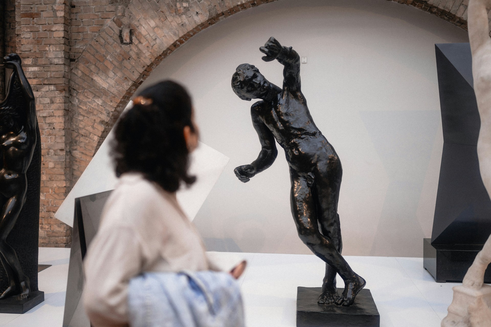 Mulher observando escultura em museu