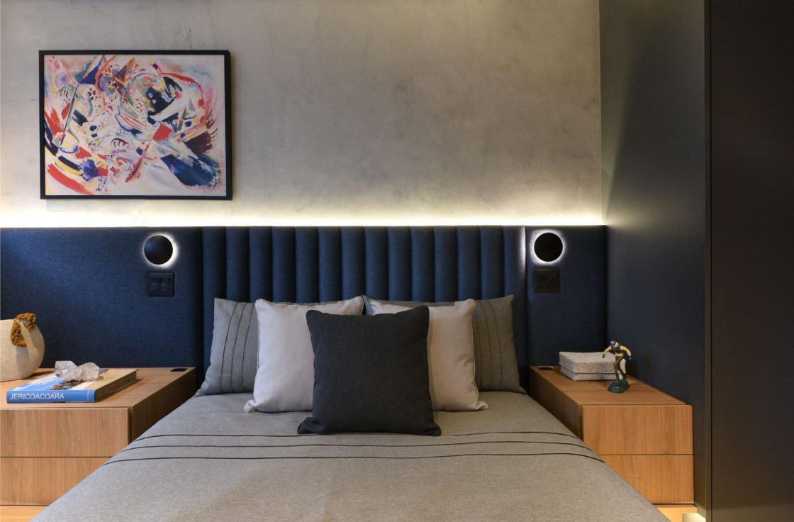cama com cabiceira azul marinho e spot na cabiceira