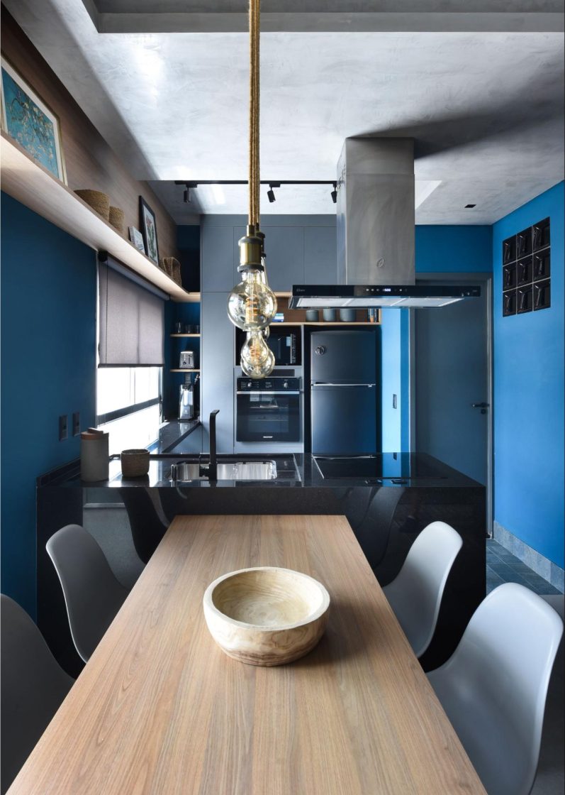sala de jantar com mesa de madeira e paredes pintadas de azul