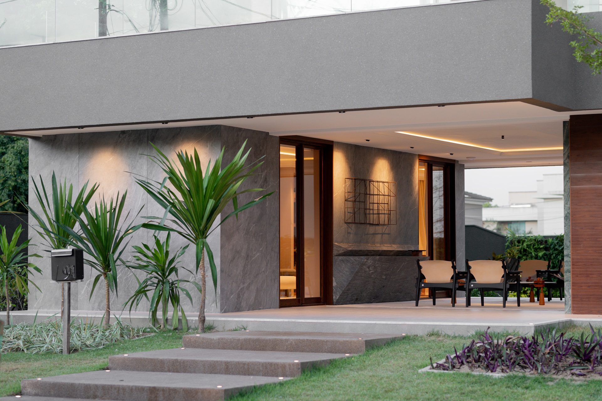 Parte da fachada da casa com porcelanato marmorizado cinza azulado e entrada para o interior