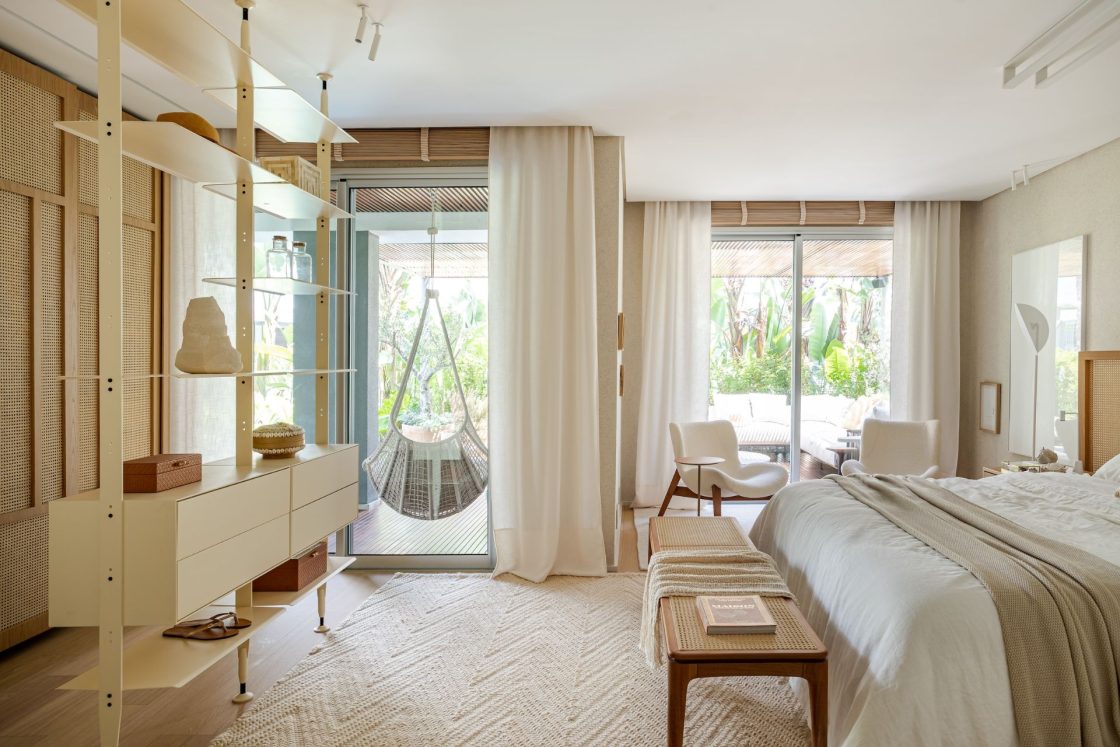 quarto com tons neutras e materiais naturais com abertura para varanda