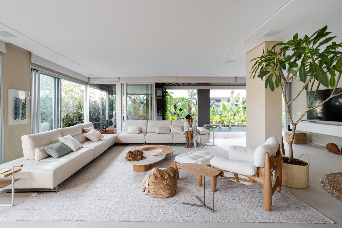 sala grande com materais naturais e paleta neutra; planta jasmim manga na sala