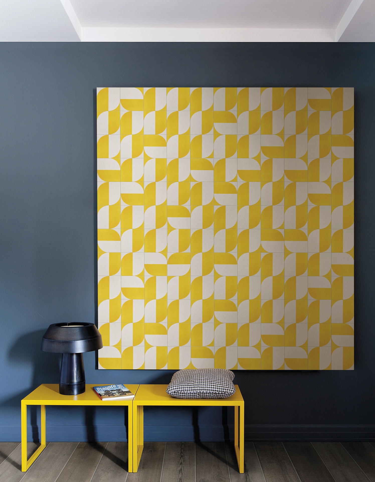 Parede em tom escuro com quadro em azulejos brancos e amarelos