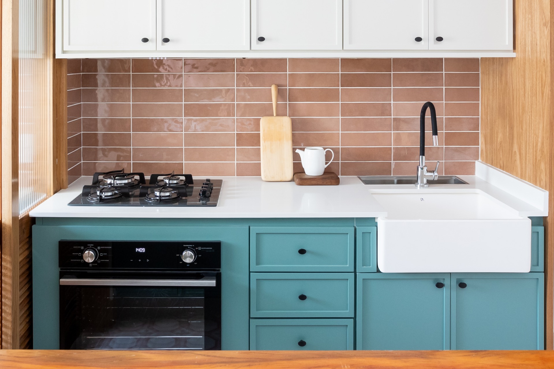 Detalhe de bancada de cozinha, com armários e revestimento na parede