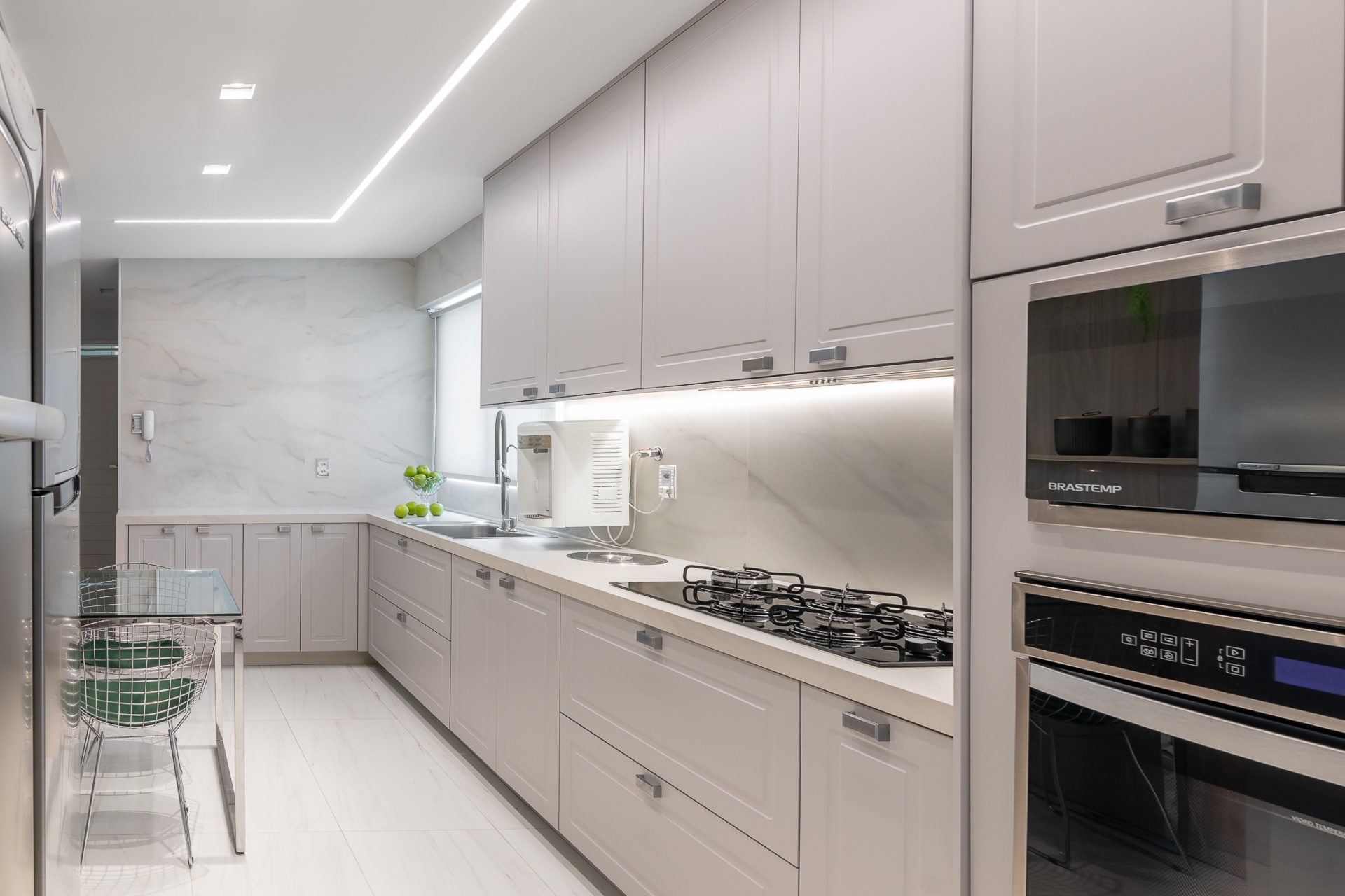 Cozinha branca com eletrodomésticos na cor preta