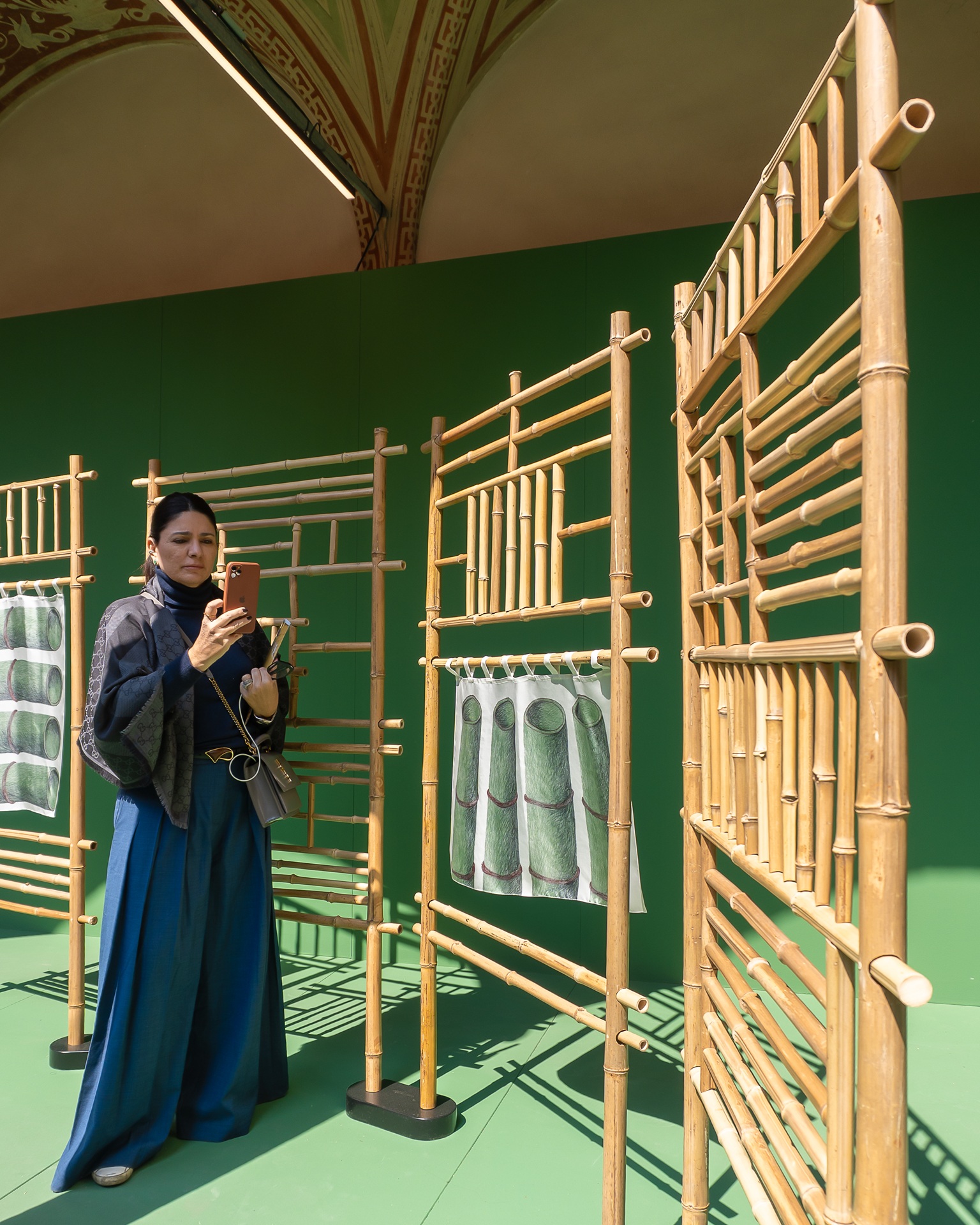 Mulher tirando foto de instalação da Gucci feita em bamboo na Fuorisalone de 2025