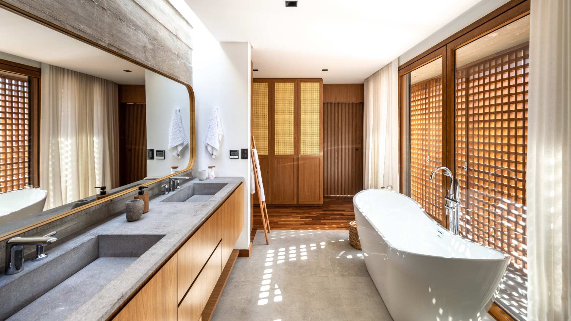 Banheiro amplo, com bancada dupla, banheira e armário