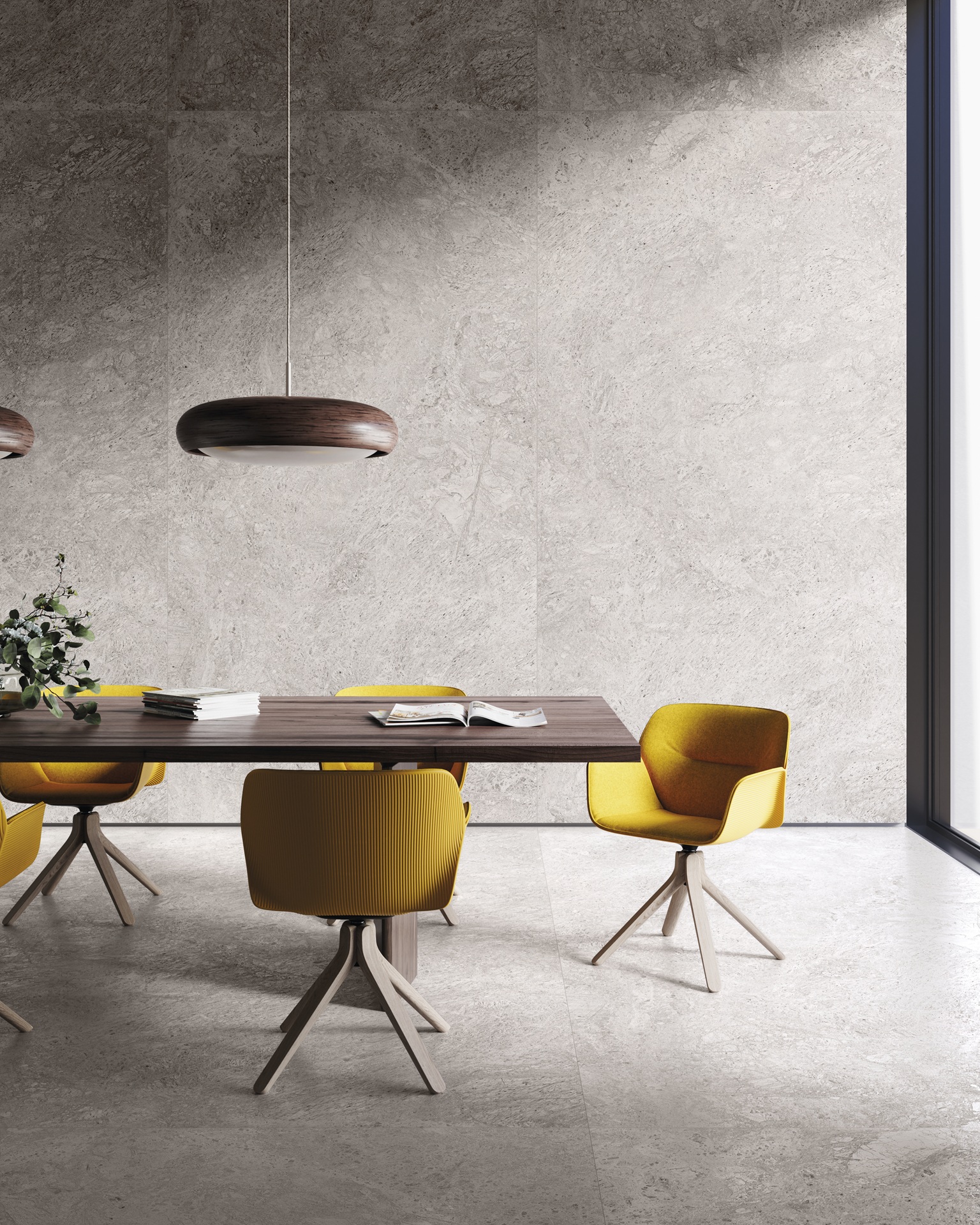 Sala de jantar com revestimento no piso e na parede reproduzindo pedra, mesa de madeira e cadeiras amarelas