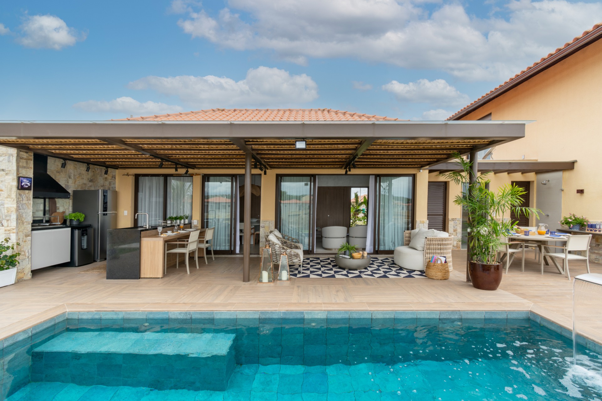 Casa amarela com piscina em primeiro plano