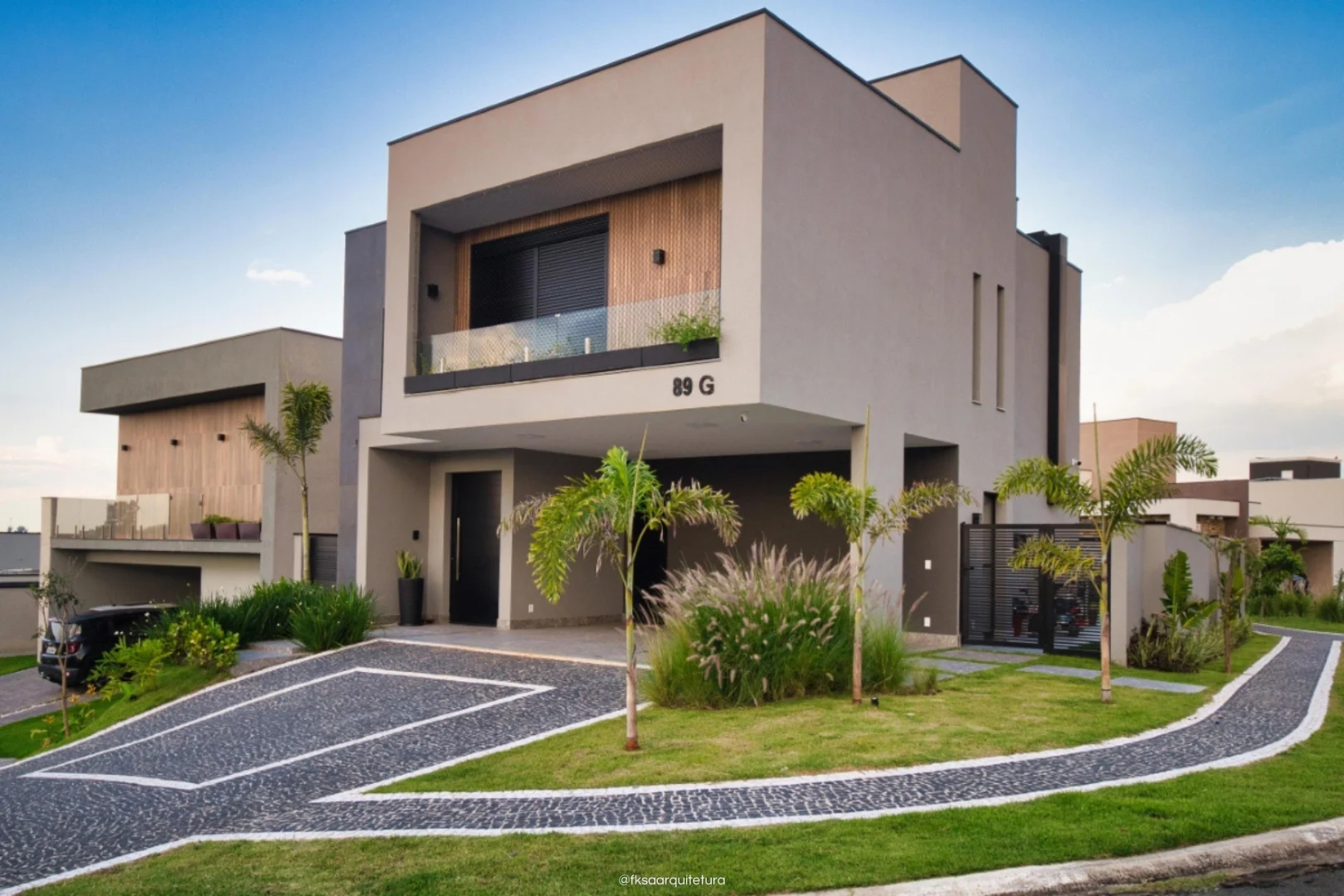 Casa em tons de marrom, rodeada por um jardim