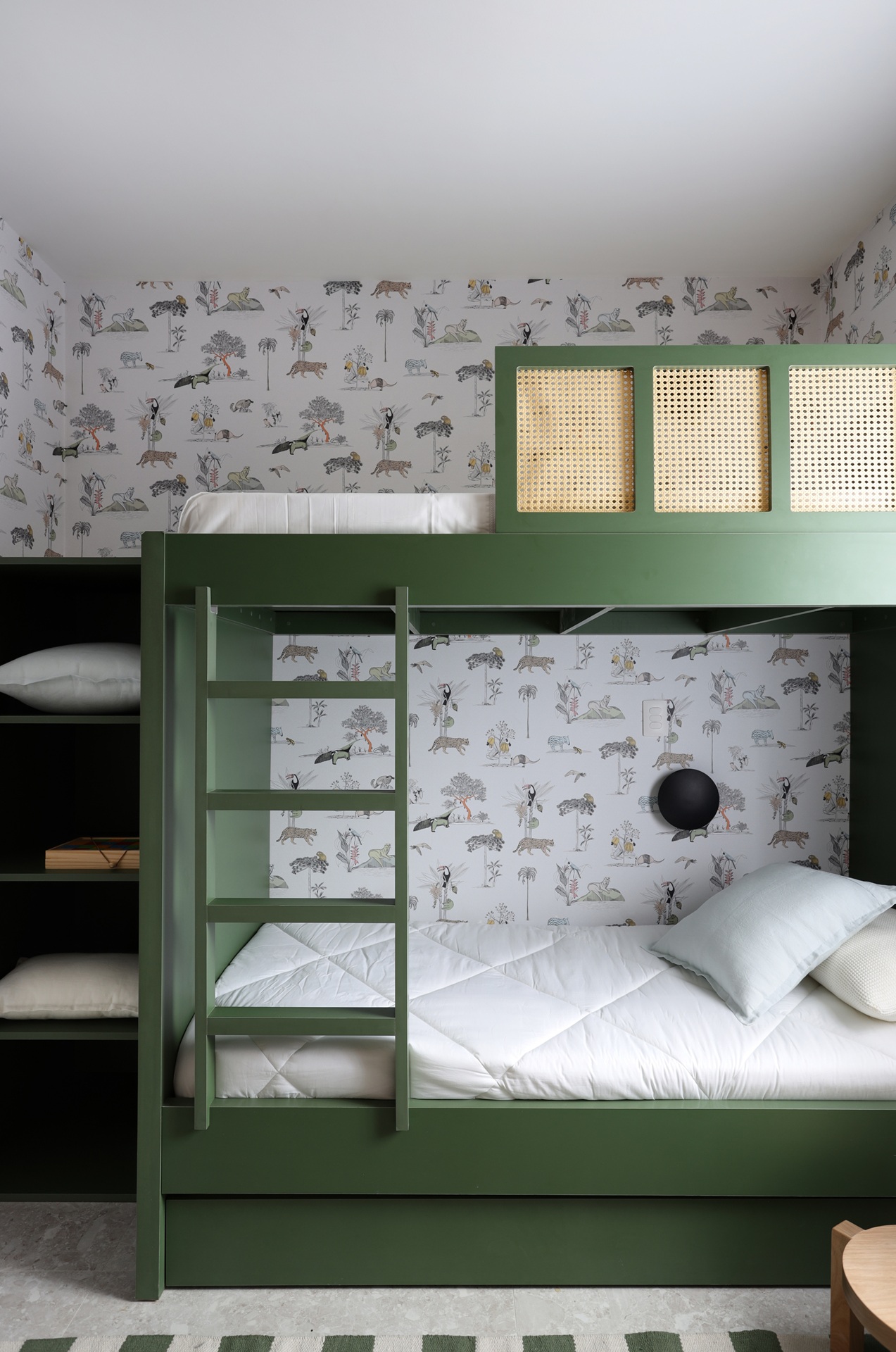Quarto infantil com beliche verde e papel de parede estampado