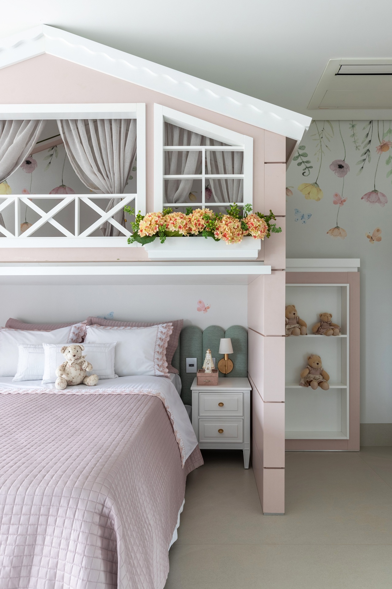 Quarto infantil de menina com casinha rosa sobre a cama