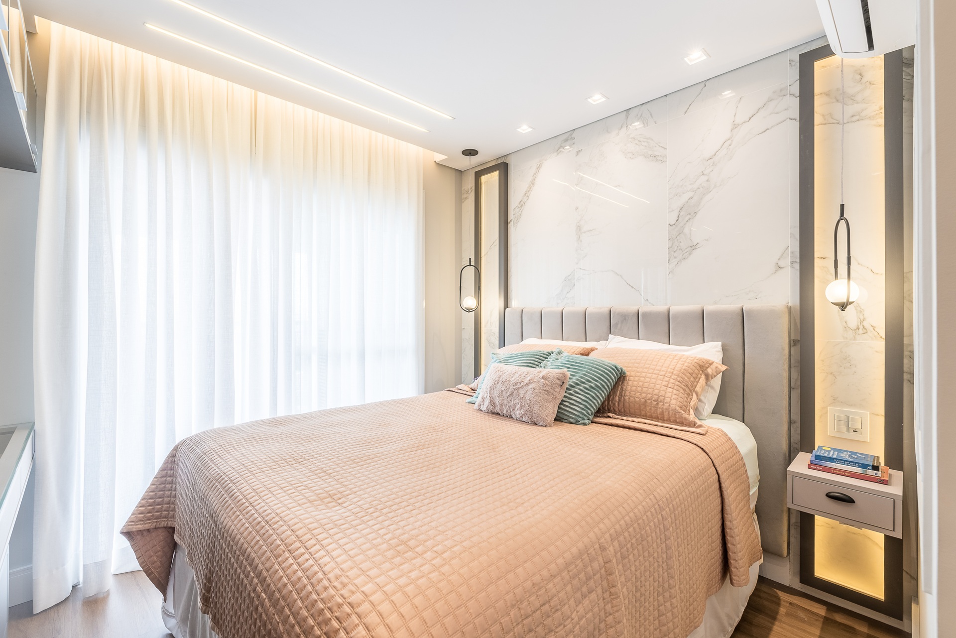 Quarto com cama de casal e cabeceira em porcelanato marmorizado branco