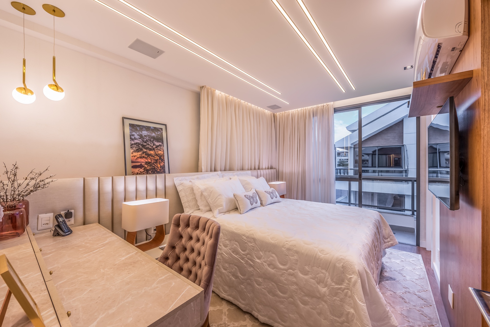 Quarto pequeno com cama de casal e televisão presa na parede