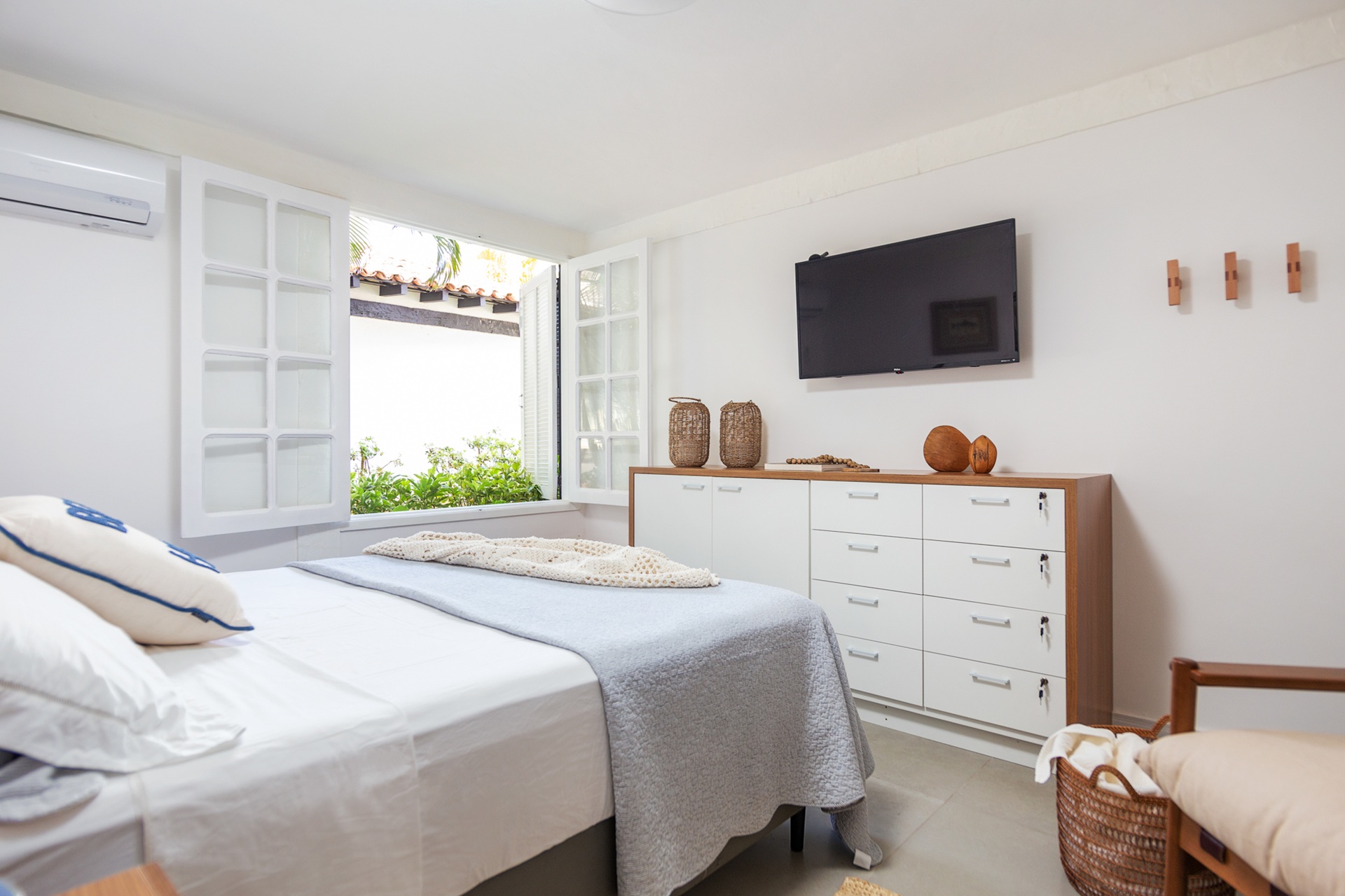 Quarto com paredes brancas e cama de casal