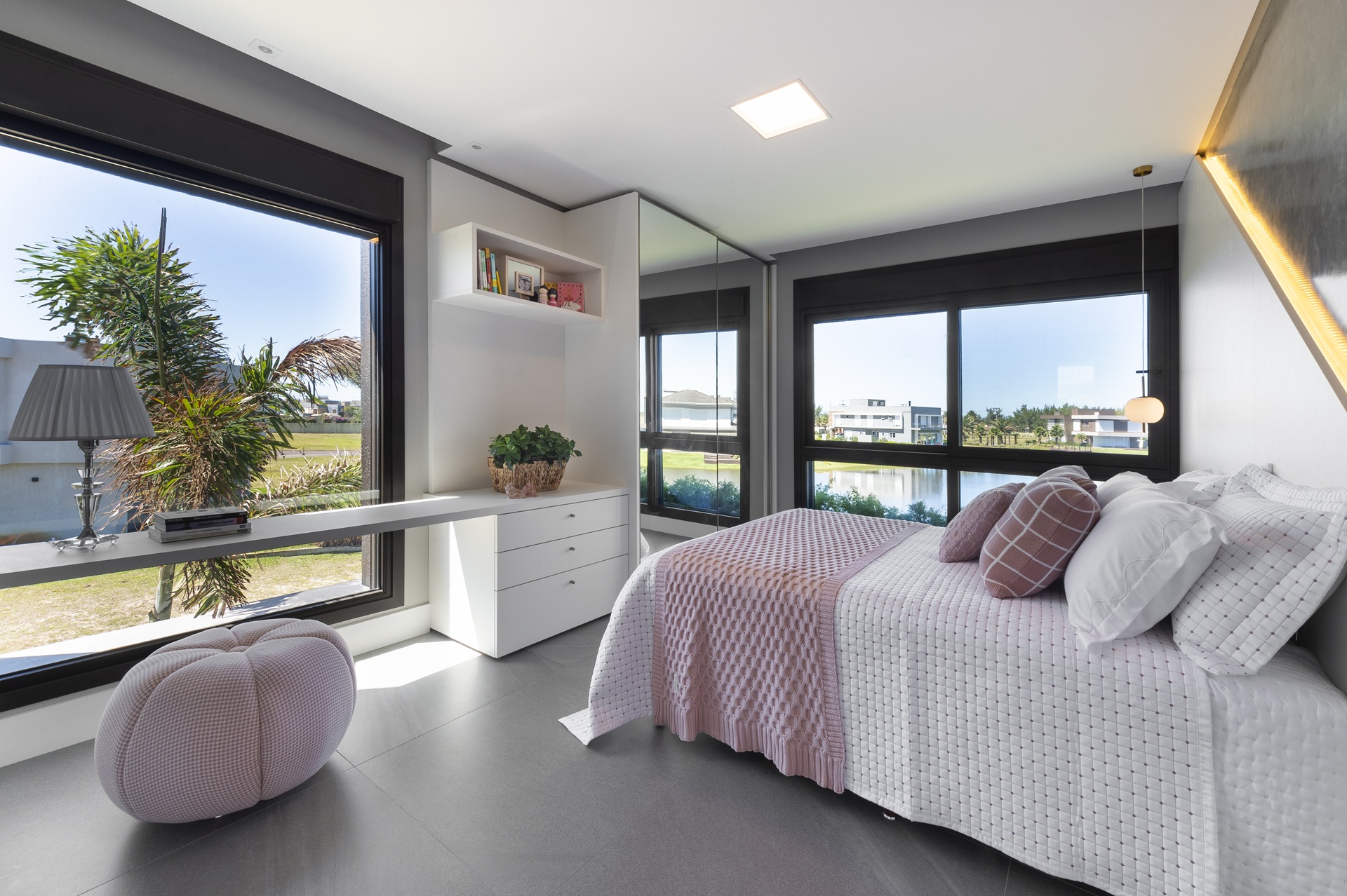 Quarto simples de menina com janelas amplas e vista para a natureza
