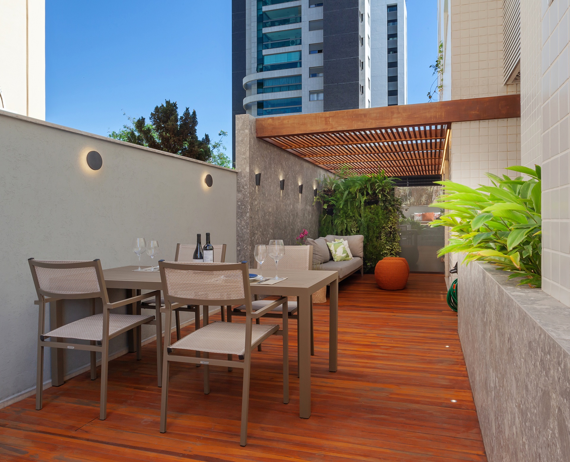 Área externa de apartamento garden com piso de madeira e mesa com quatro cadeiras