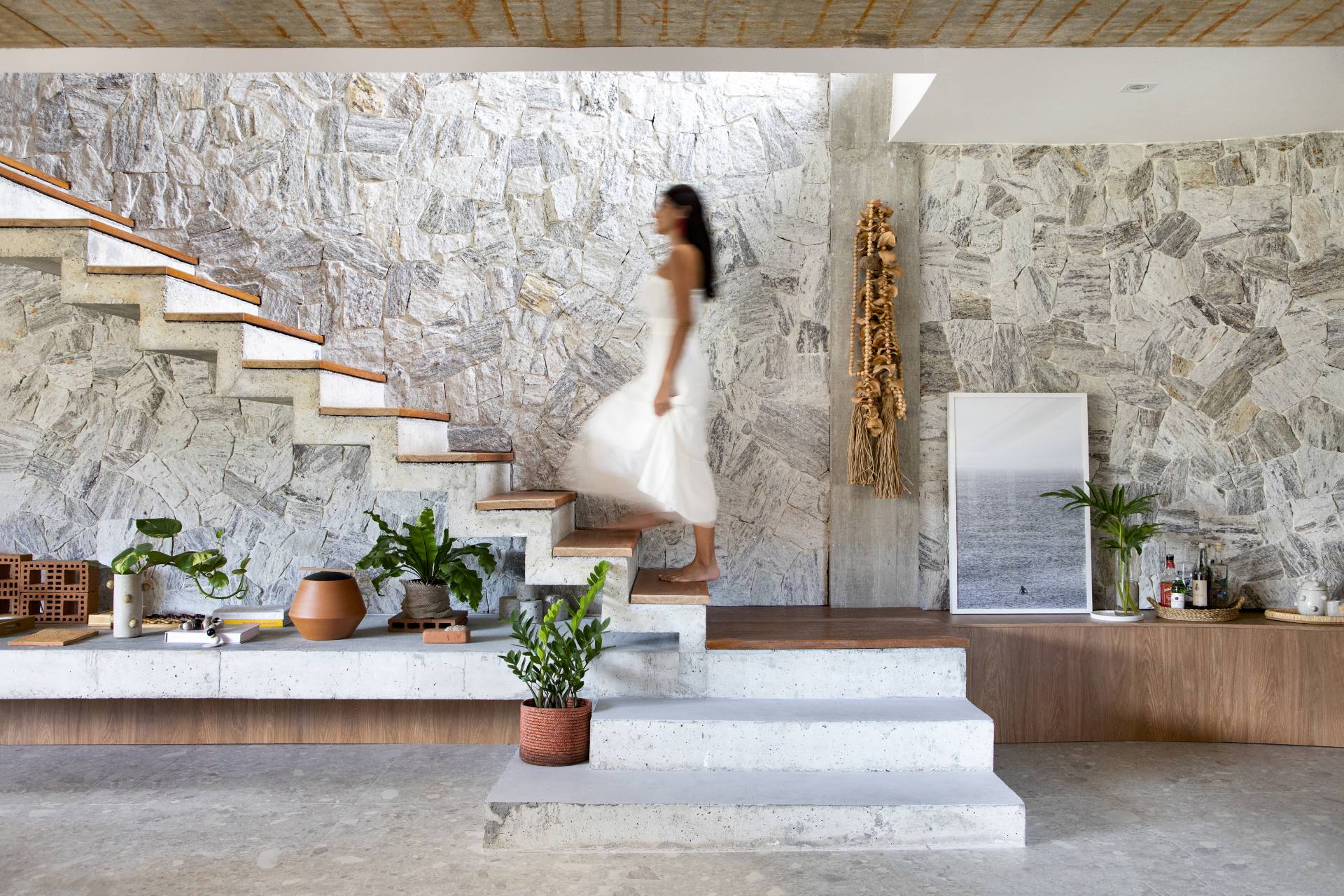 Muro de pedra na parede da casa com escada branca, material natural na decoração