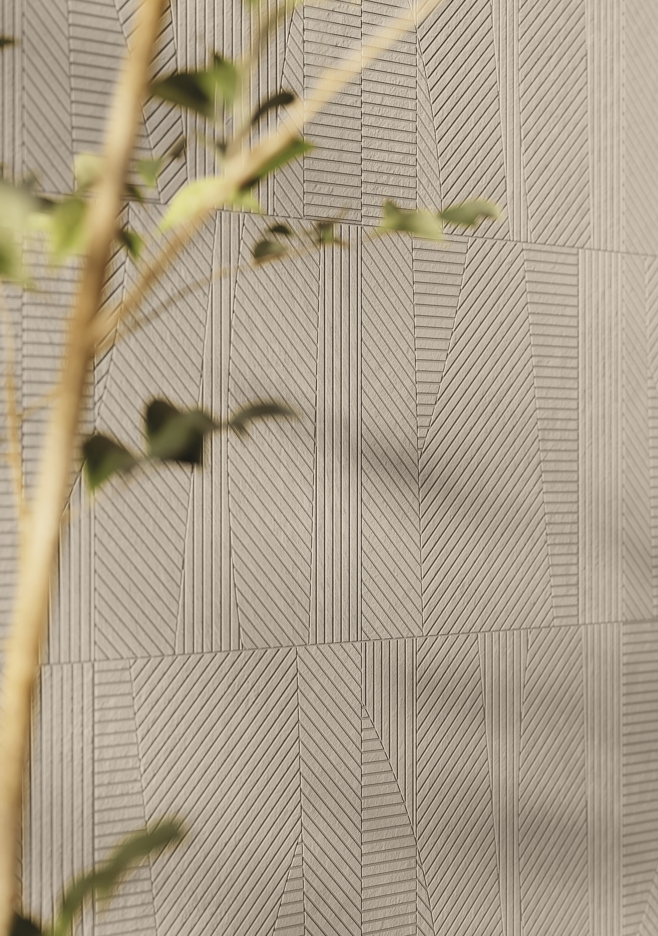 Detalhe de parede com revestimento da linha Hachuras em tom de bege e galho de planta desfocado no primeiro plano