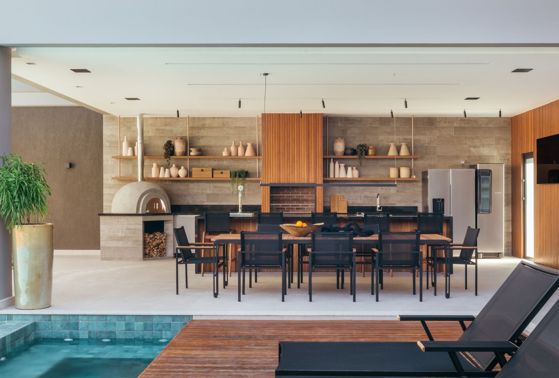 Área externa com cozinha gourmet com vista para a piscina