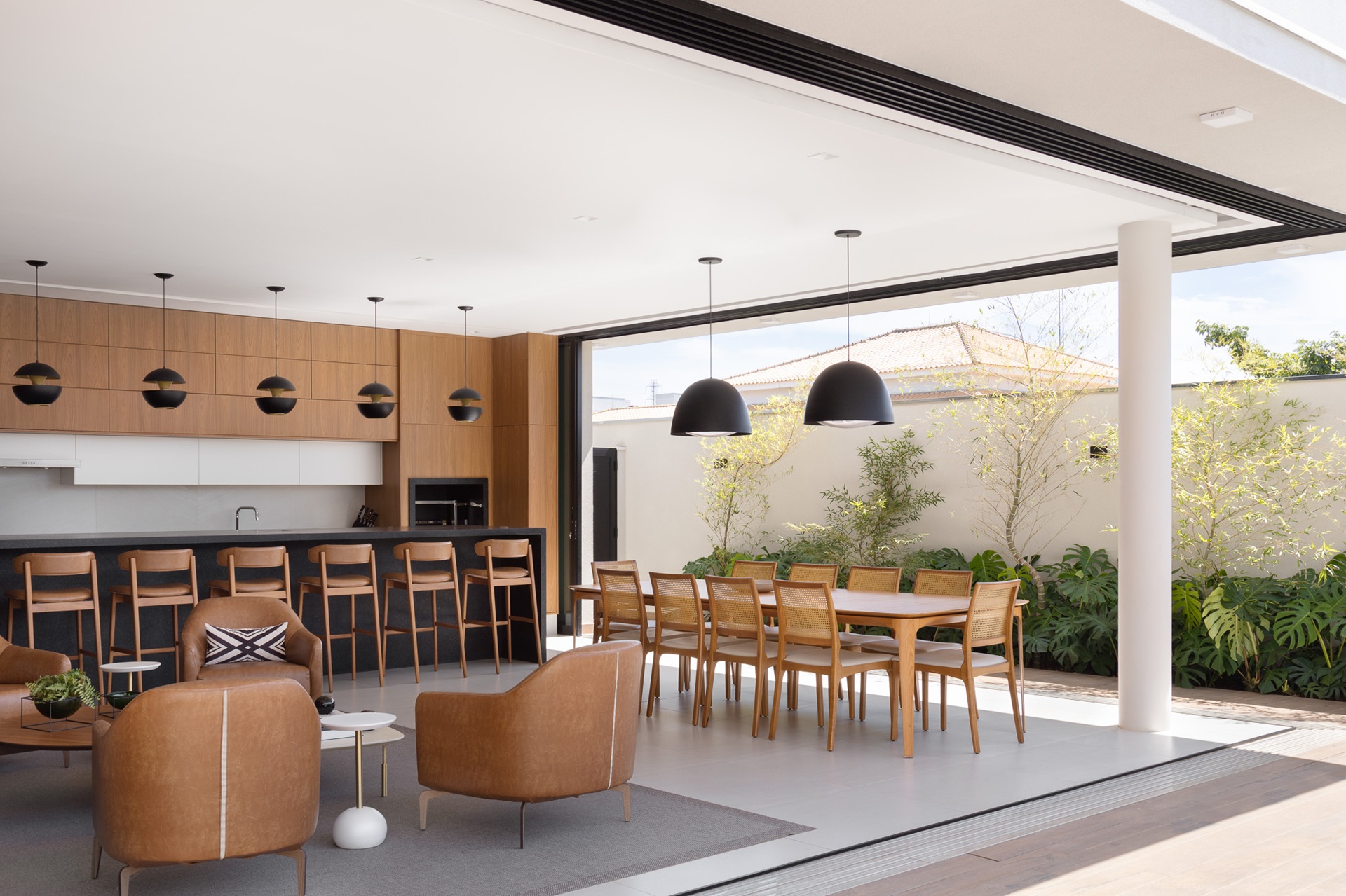 Área gourmet coberta com churrasqueira integrada ao espaço externo da casa
