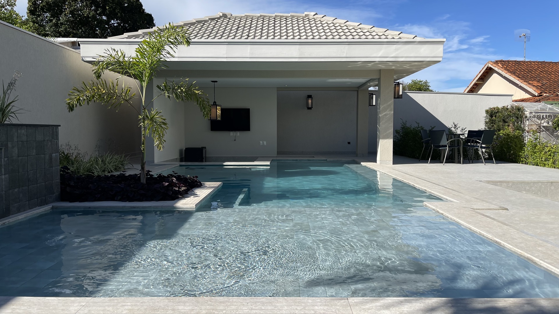 bar molhado Piscina dividida em três partes: prainha com cascata, com espaço para as espreguiçadeiras; parte funda, com bancos nas laterais; e o bar molhado