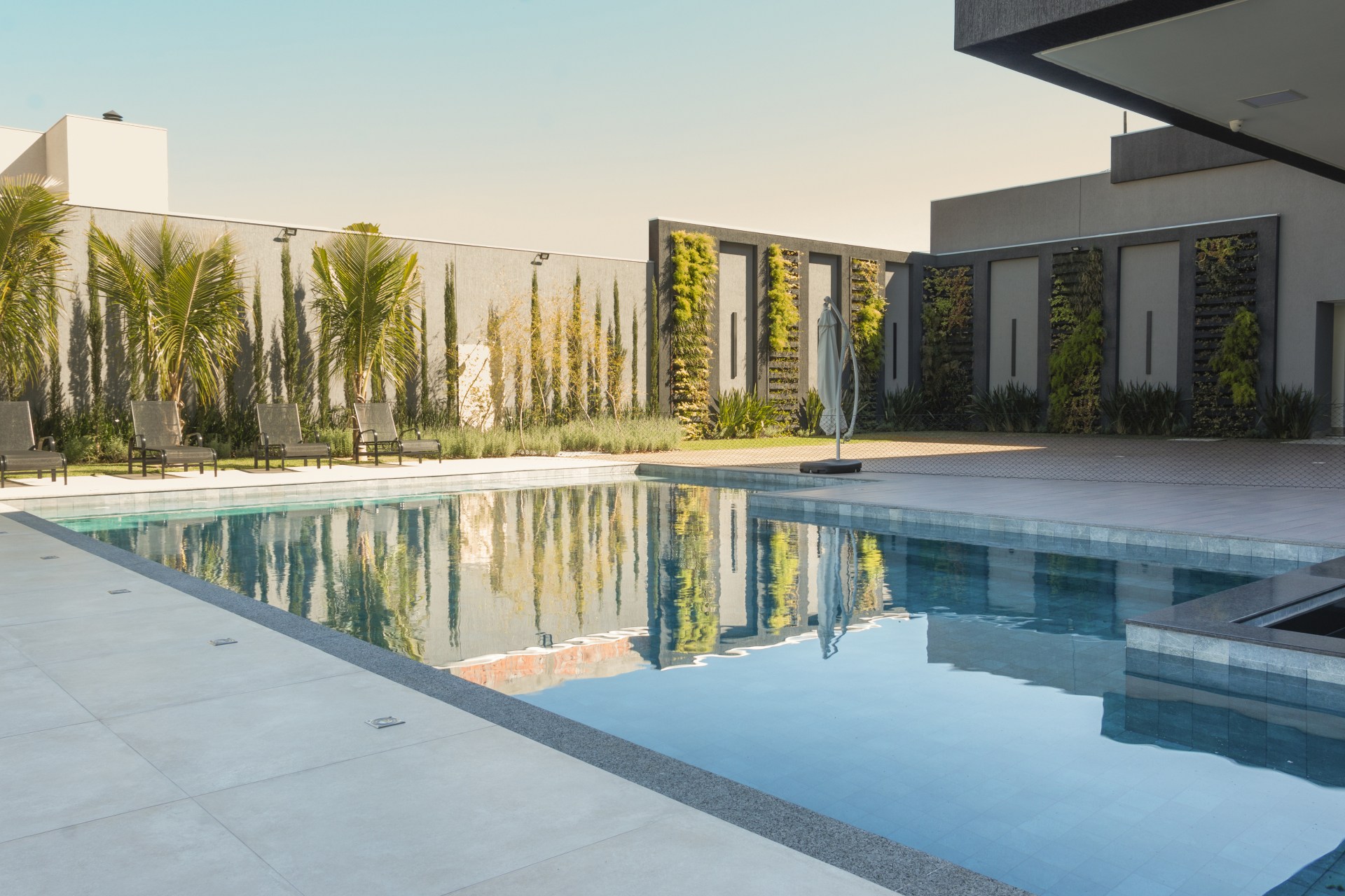 Piscina integrada a espaço gourmet por meio de um bar molhado