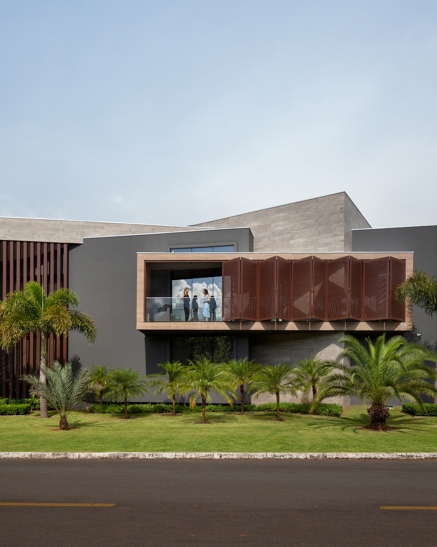 Casa contemporânea com diferentes volumes em fachada que traz madeira e concreto
