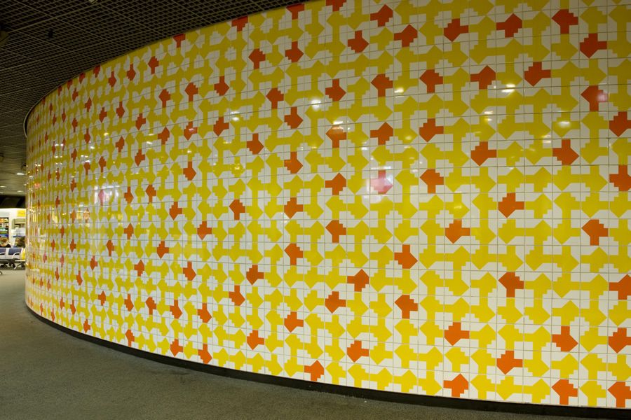 Painel de Athos Bulcão no Aeroporto de Brasília, formado por azulejos brancos, amarelos e vermelhos em padrões geométricos que criam movimento e ritmo visual