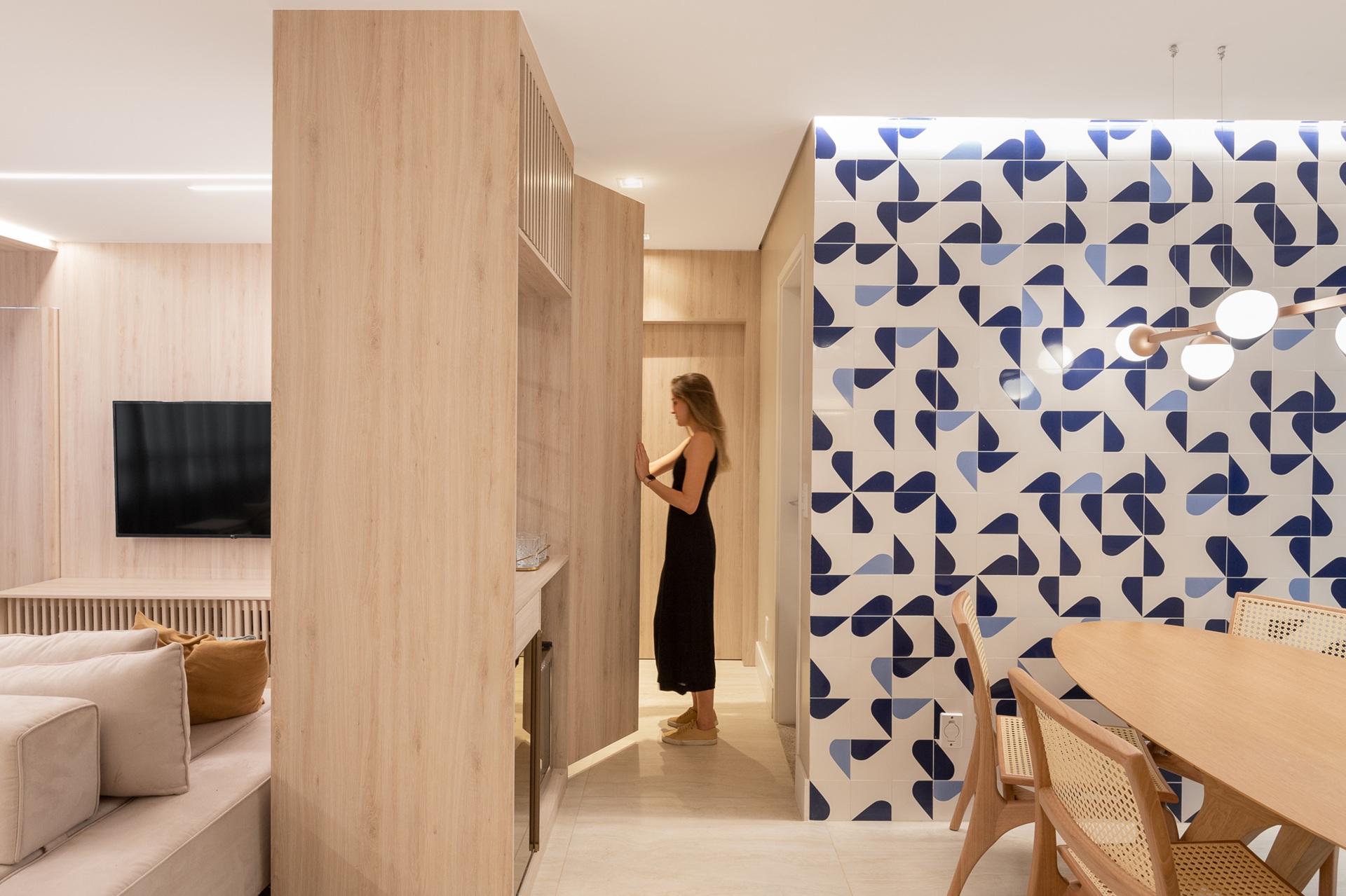 athos bulcão Sala integrada de estar, TV e jantar, com tons claros e painel de azulejos em branco e azul, inspirados no estilo de Athos Bulcão