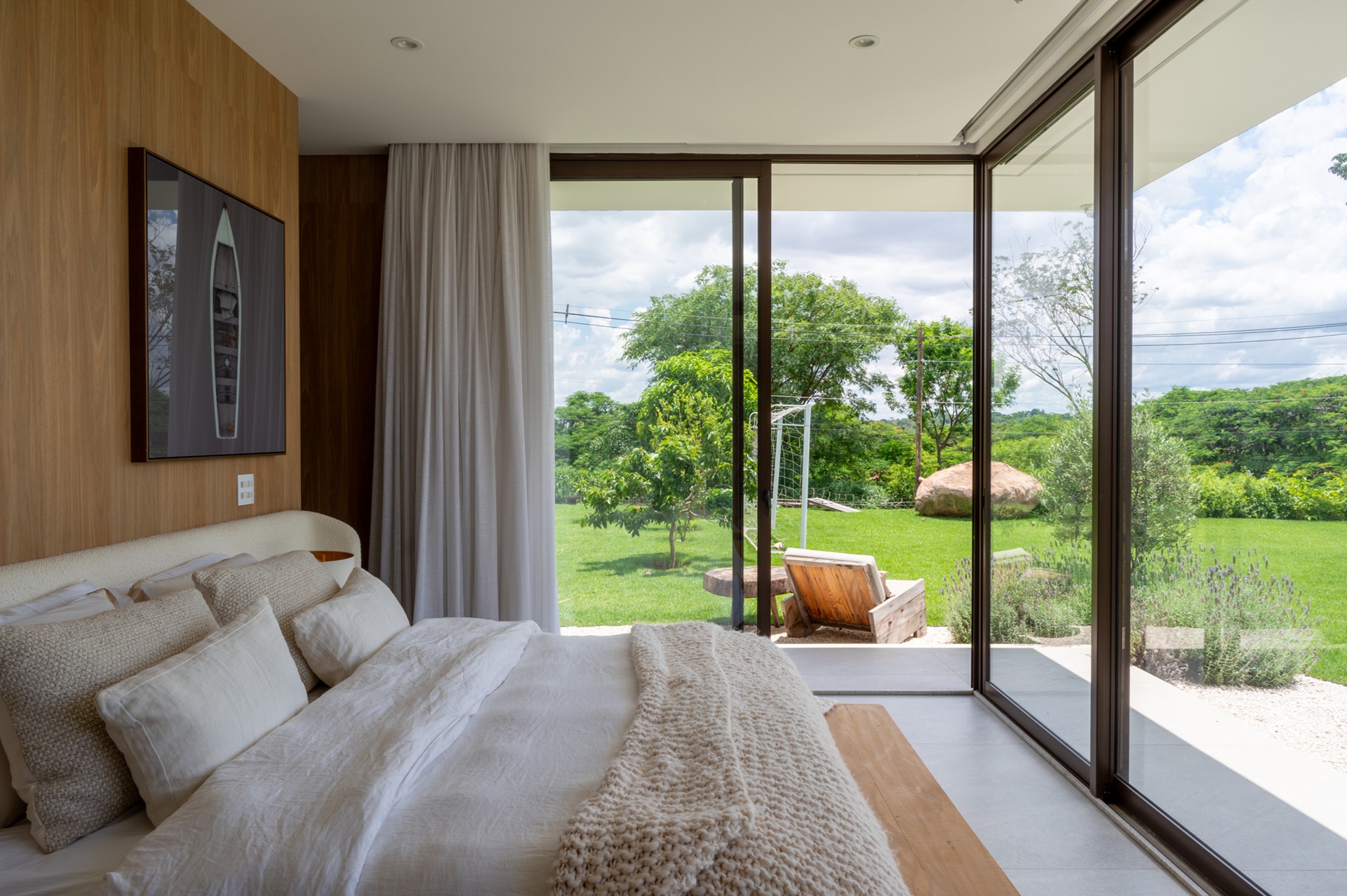 Quarto com fechamento de vidro e visão para o jardim