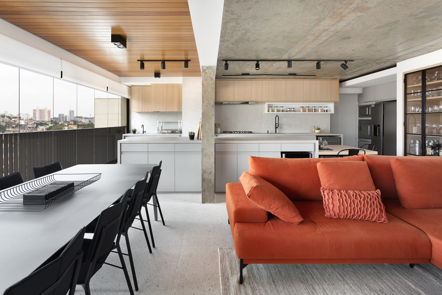 Living integrado a espaço gourmet em apartamento com teto em concreto aparente