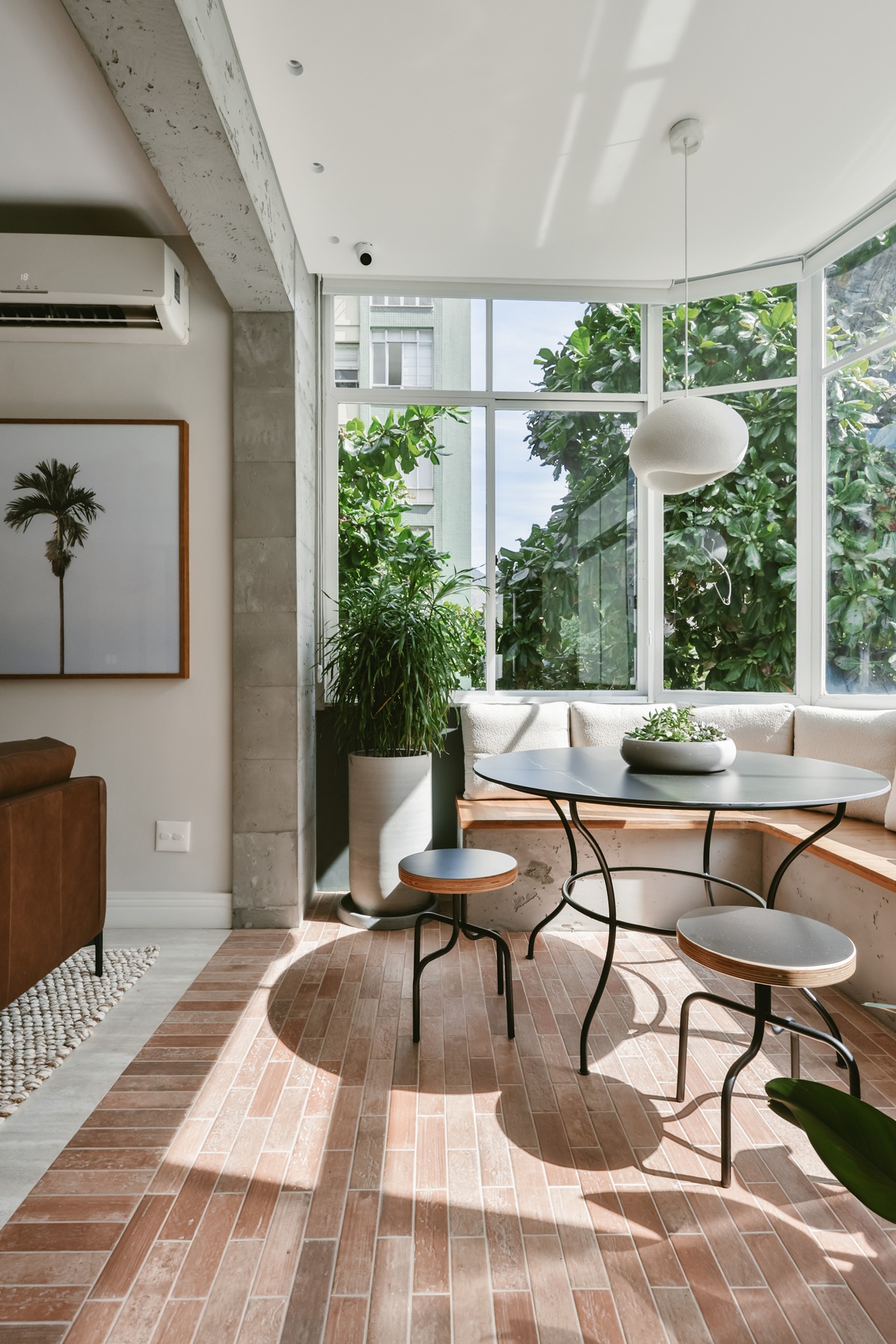 Varanda de apartamento com fechamento em vidro e viga em concreto aparente