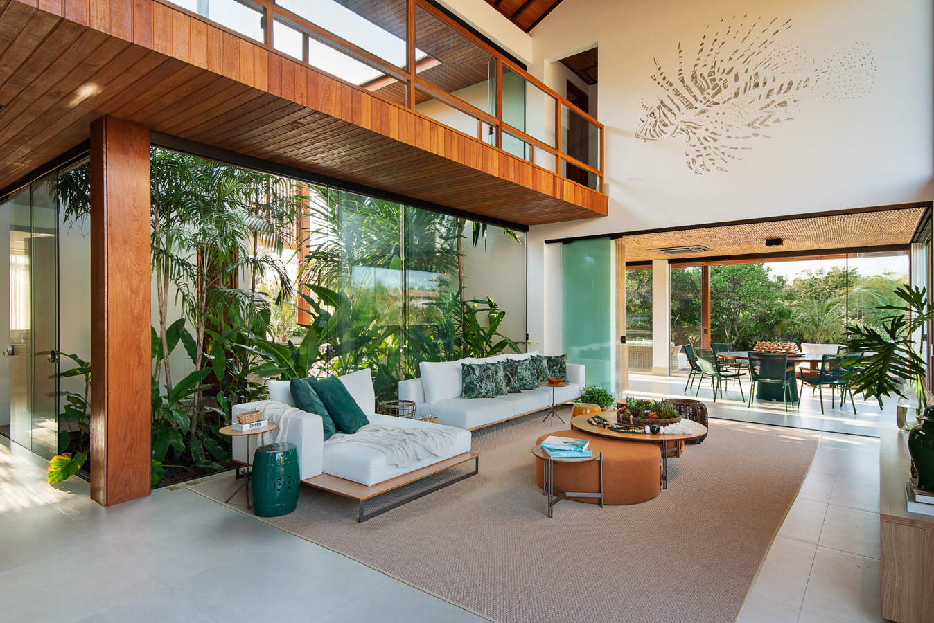 Living amplo com pé direito alto e jardim de inverno cercado por vidros