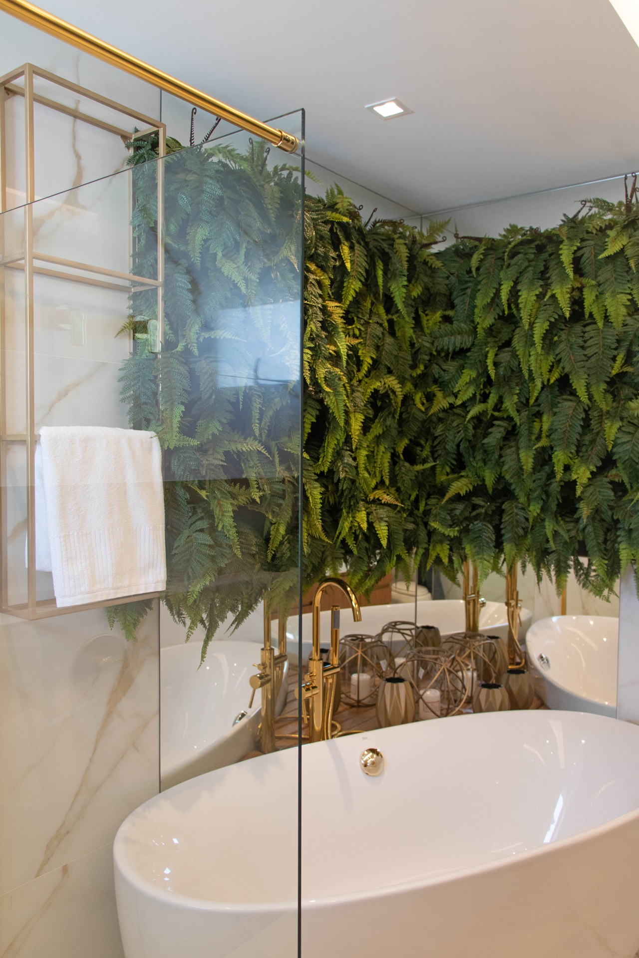 Banheiro com revestimento marmorizado branco e parede com painel verde