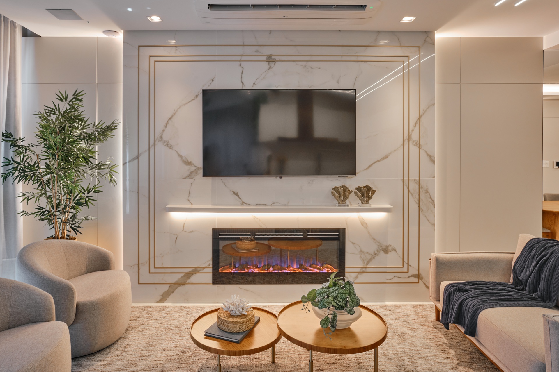 Sala em estilo clássico com painel de televisão em porcelanato que recria mármore branco