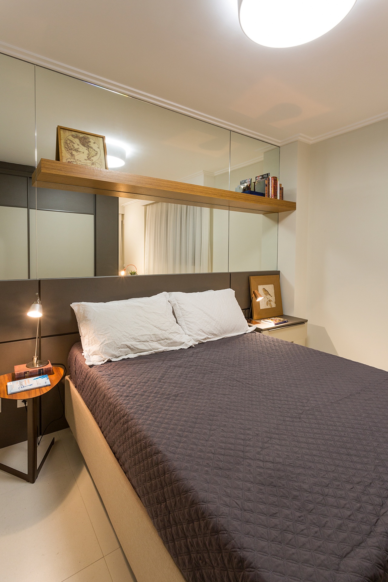 Quarto com cabeceira da cama espelhada e detalhes em madeira e metal