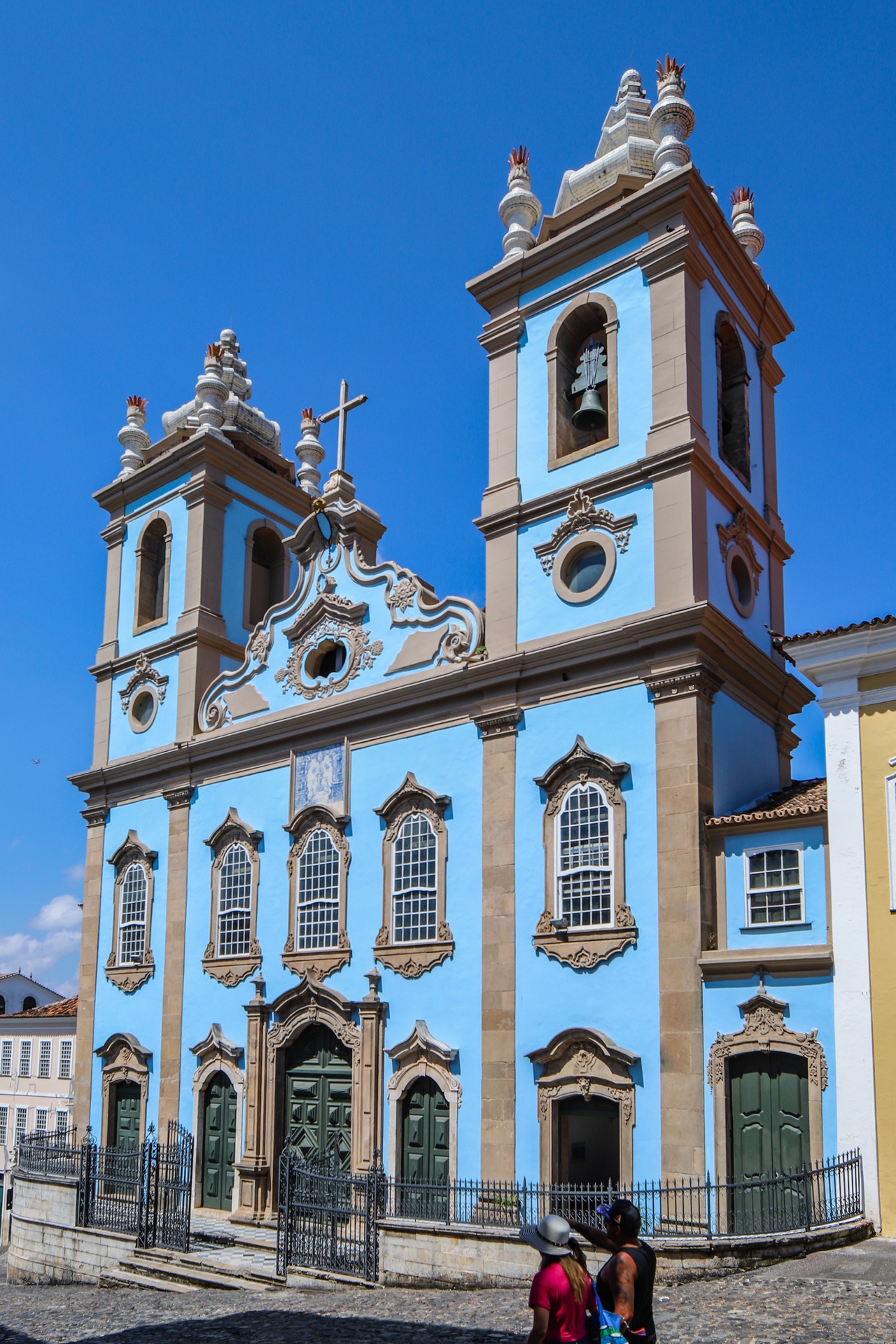 igrejas pelo mundo Fachada da Igreja de Nossa Senhora do Rosário dos Pretos, em Salvador, com torres simétricas, janelas emolduradas em pedra e pintura azul-celeste.