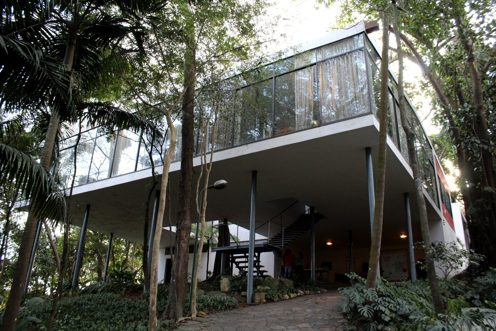 Registro de baixo para cima da Casa de Vidro, construção modernista sobre pilares e blocos de aço e vidro