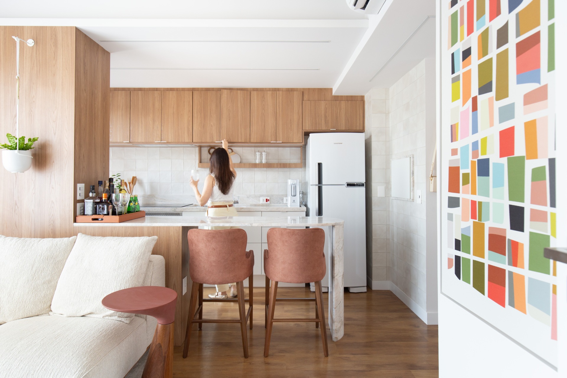 Mulher em cozinha com sala integrada