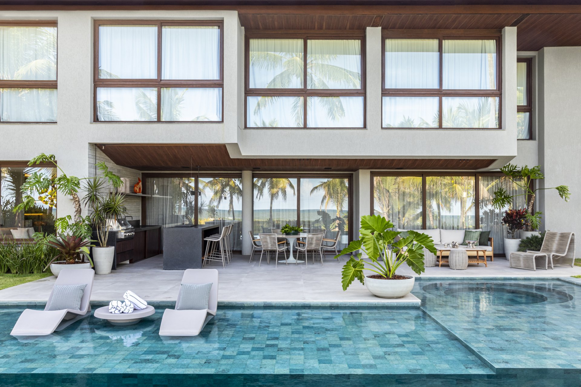 Fachada de casa de praia com aberturas de aço