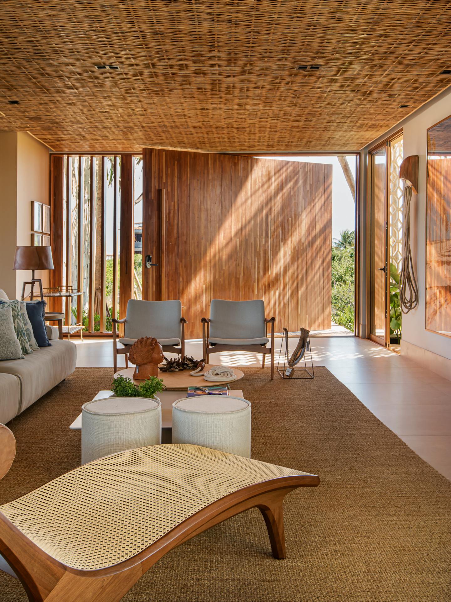 Sala de estar com porta de entrada pivotante em madeira