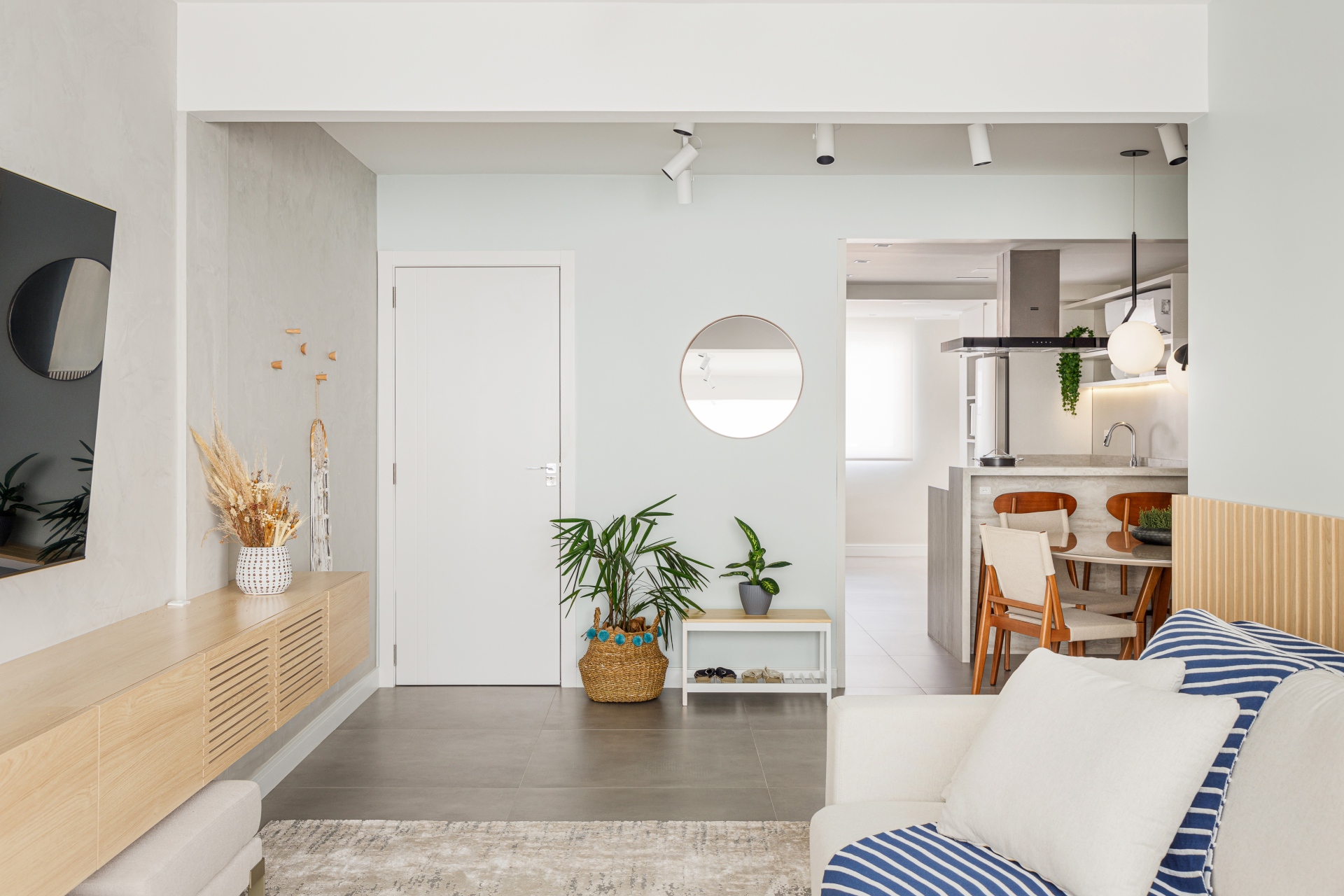 Entrada integrada ao living com decoração leve, plantas e tons claros