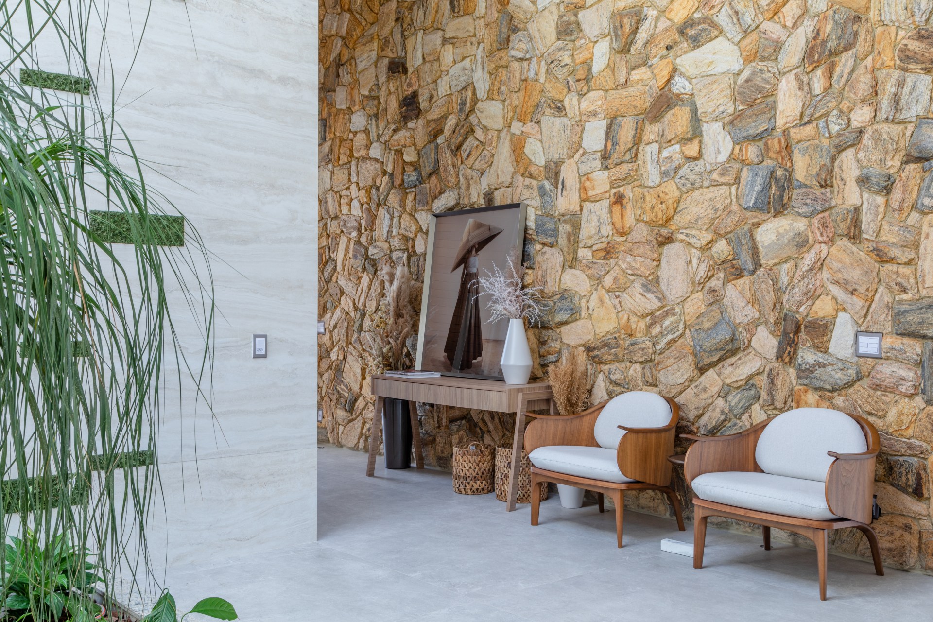 Hall com parede de pedras naturais e mobiliário em madeira clara