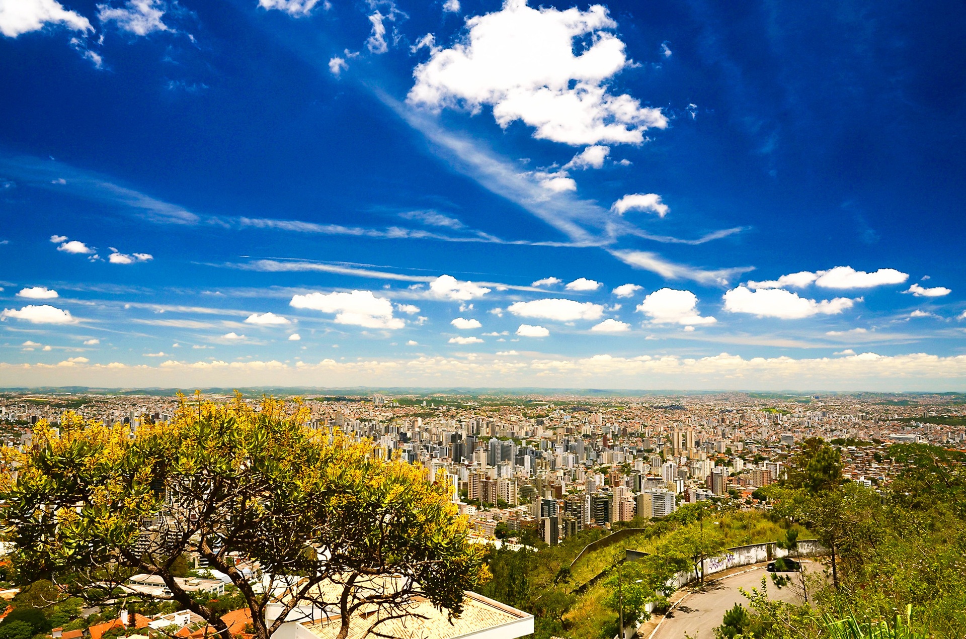 cidade jardim Vista panorâmica de Belo Horizonte a partir do Mirante das Mangabeiras. A imagem mostra a extensa malha urbana da capital mineira integrada ao relevo e à vegetação nativa, destacando a característica planejada da cidade e sua vocação de cidade-jardim, com áreas verdes e horizonte aberto.