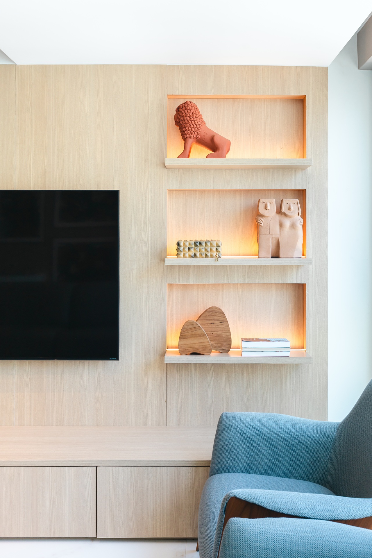 Parede de televisão com nichos com esculturas artesanais