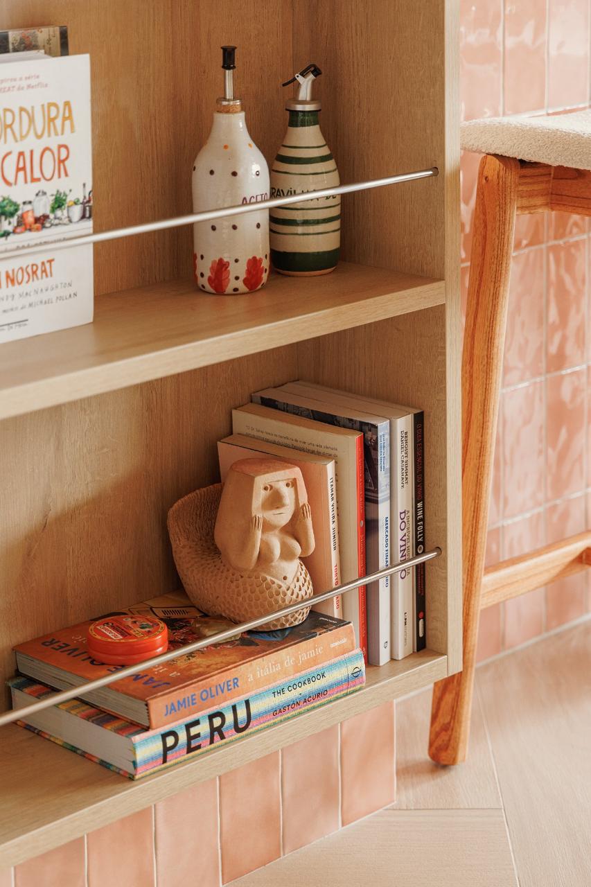 Estante em cozinha com livros e peças artesanais
