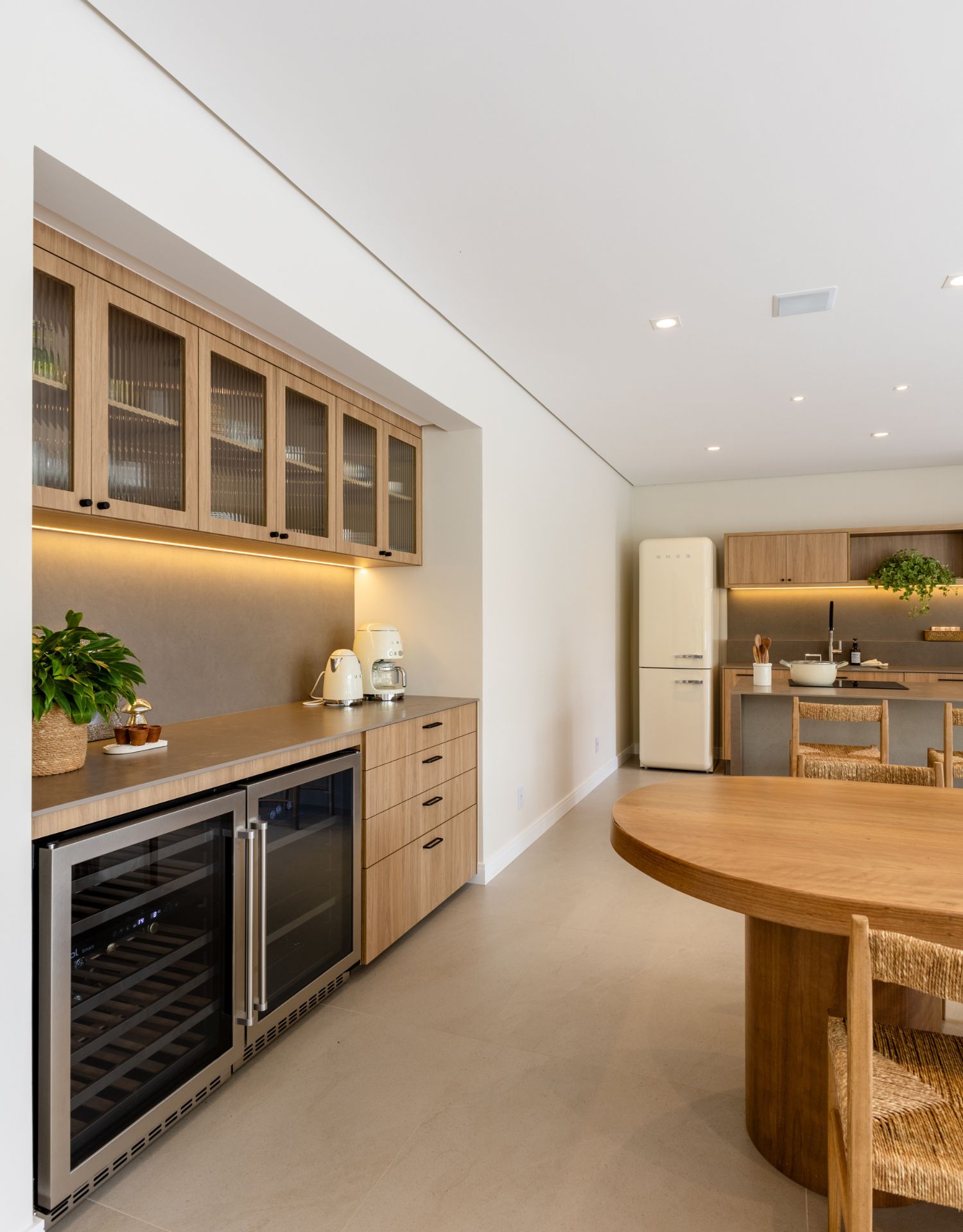 Área gourmet com mobiliário em madeira e cores neutras