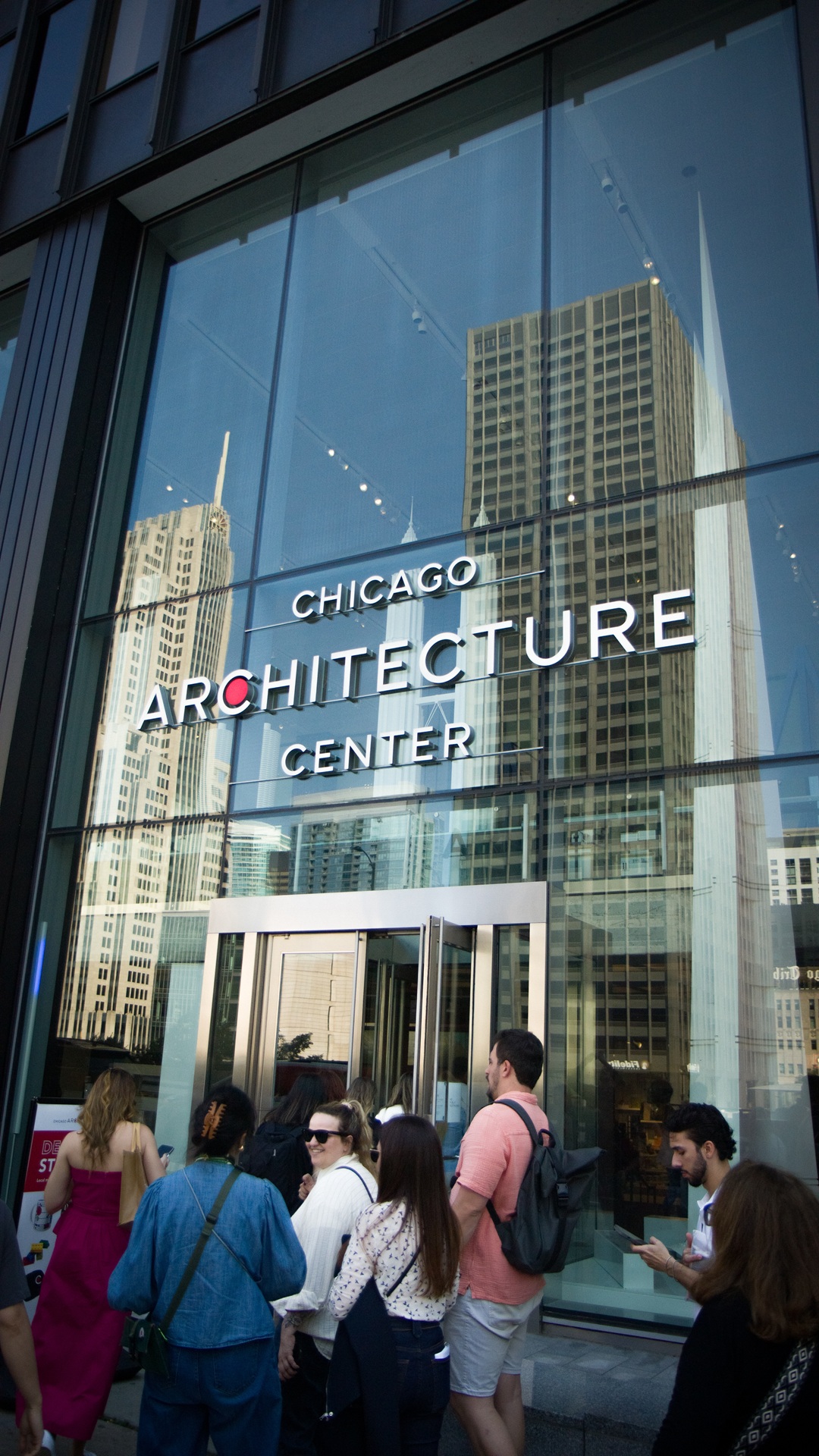 Entrada do Chicago Architecture Center com participantes passando pela porta